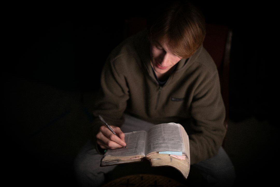 Croatian author writing at a wooden desk by lamplight with an old typewriter